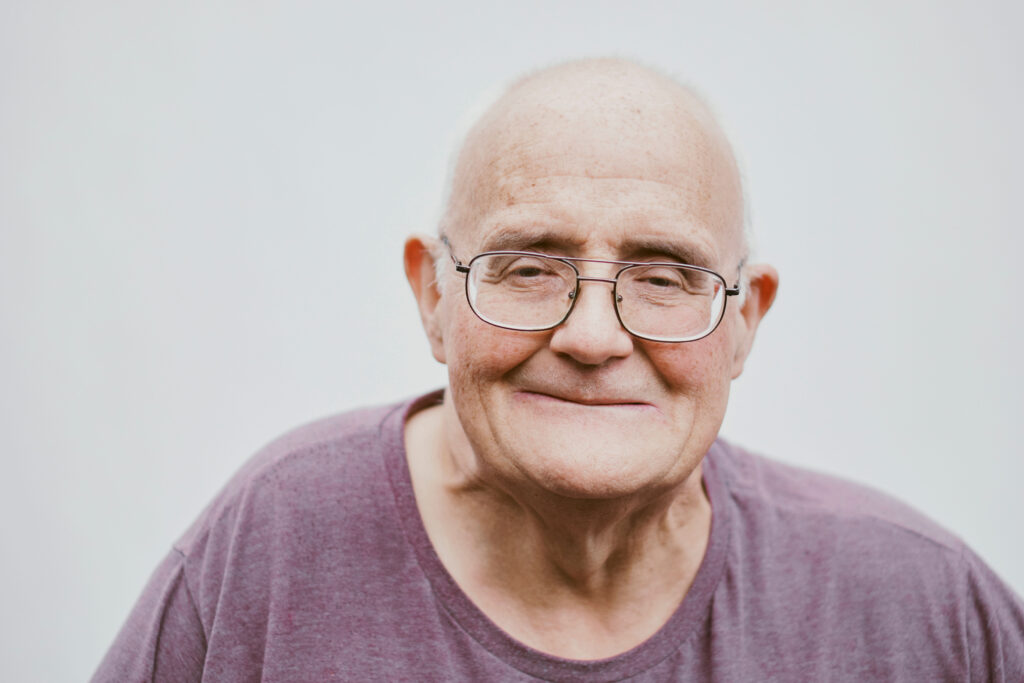 An elderly man smiling at the camera
