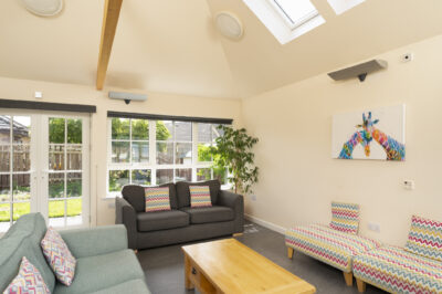 A sunroom with sofas and a table with french doors.
