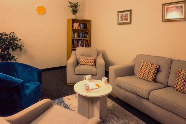 Cosy room with sofa, bookcase and table.