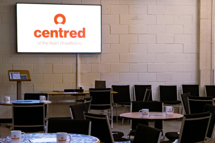 Event room with large screen, tables and chairs