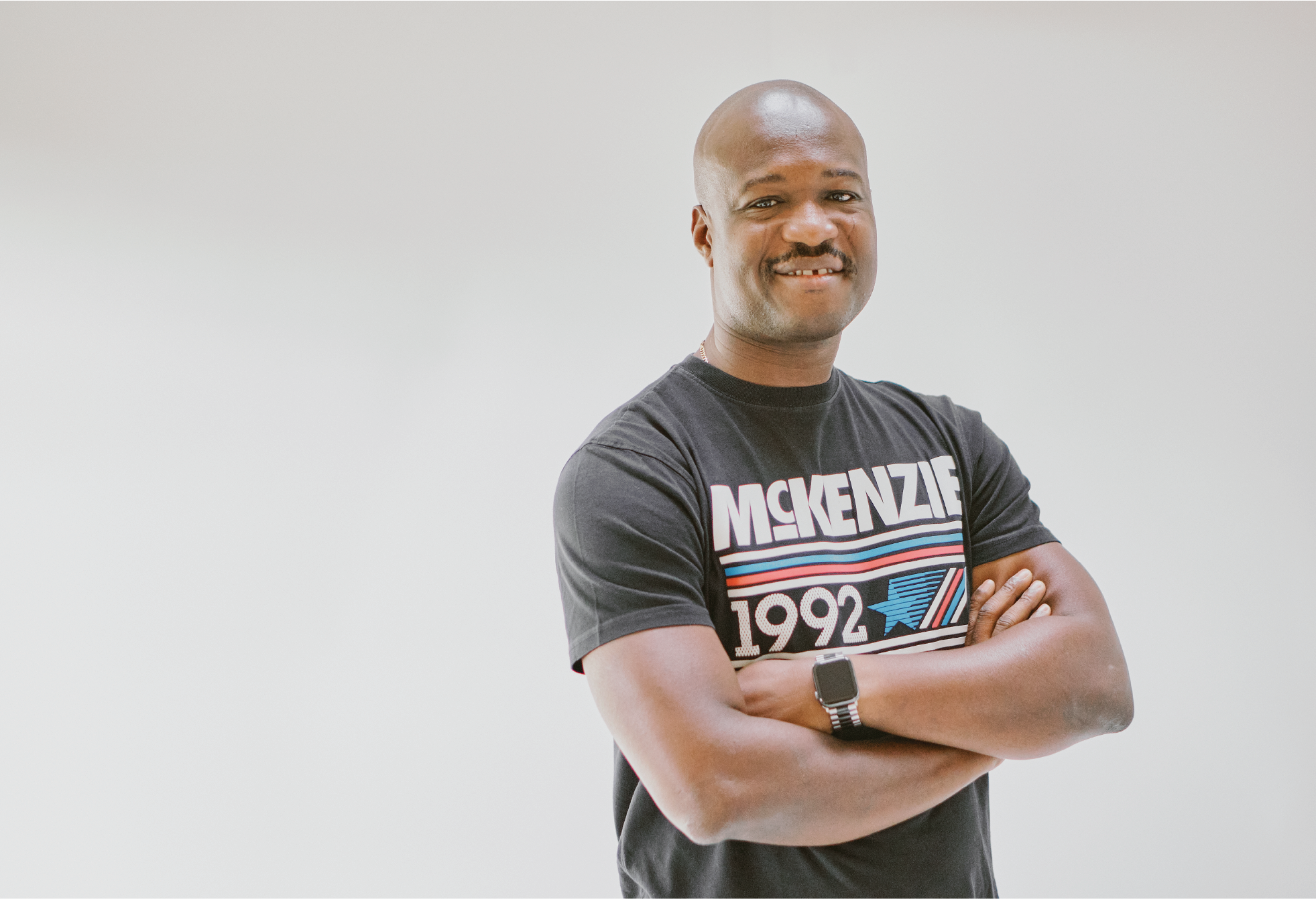 Man smiling with his arms folded.