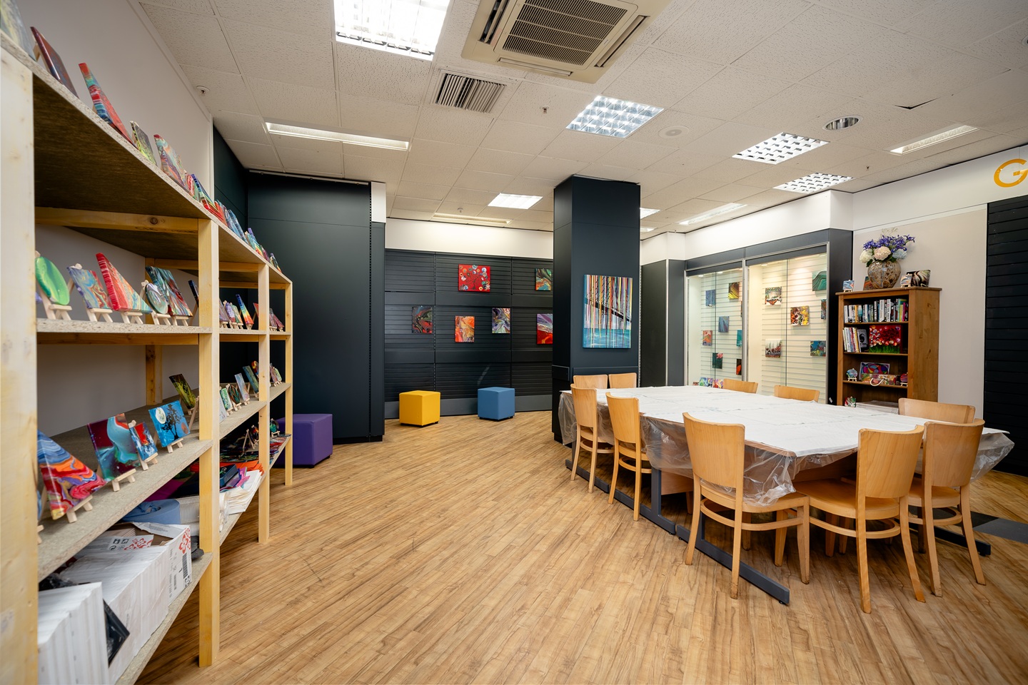 Studio room with desk, chairs and shelves.