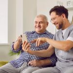 A male support worker helping an older man