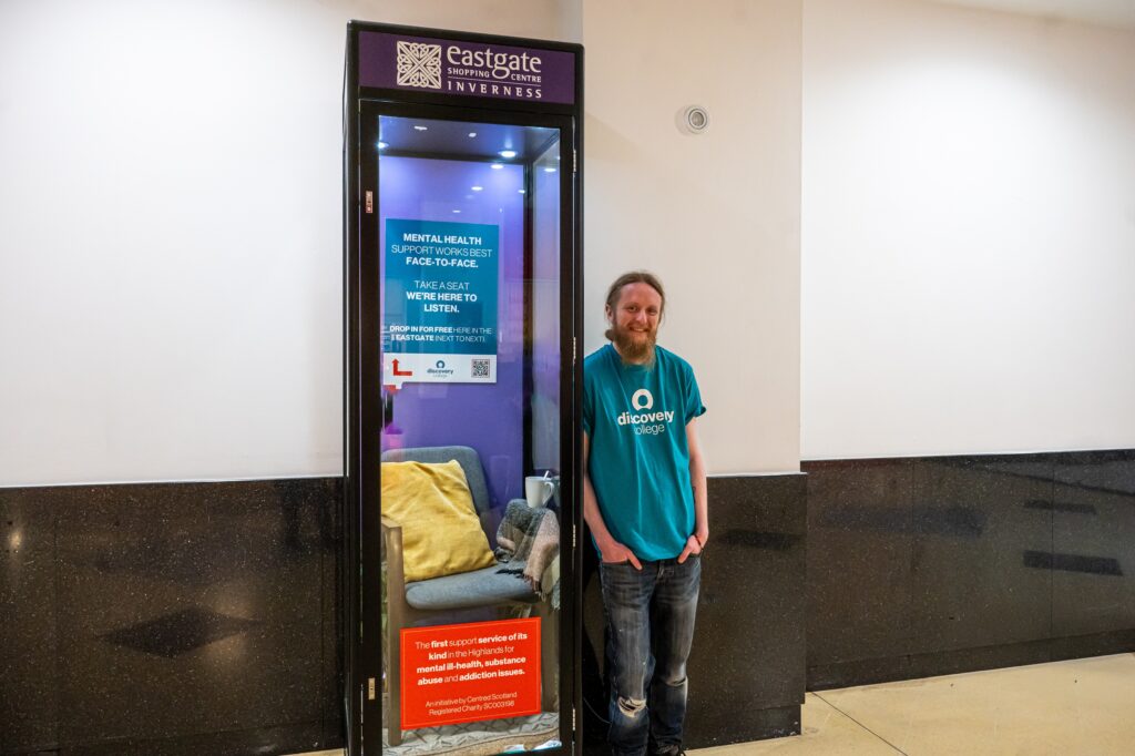 Man standing beside display cabinet about mental health
