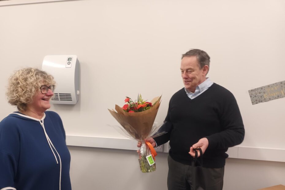 A man with a bouquet of flowers about to give to a smiling woman