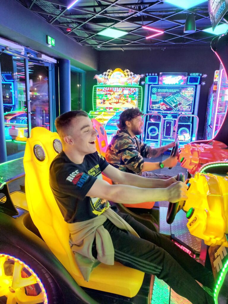 Young men playing arcade games and laughing