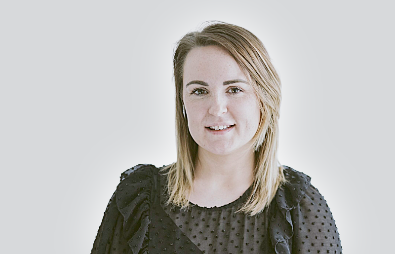 Photo of young woman with blonde hair and smiling at the camera