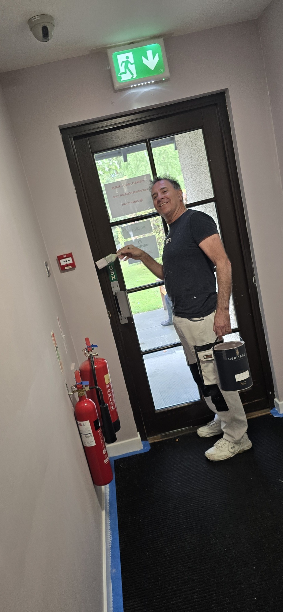 Painter with paint and paint brush decorating a wall