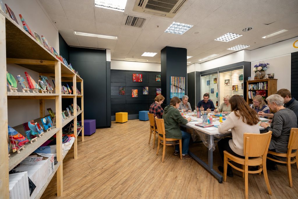 Art room with a group of people doing wellbeing crafts.