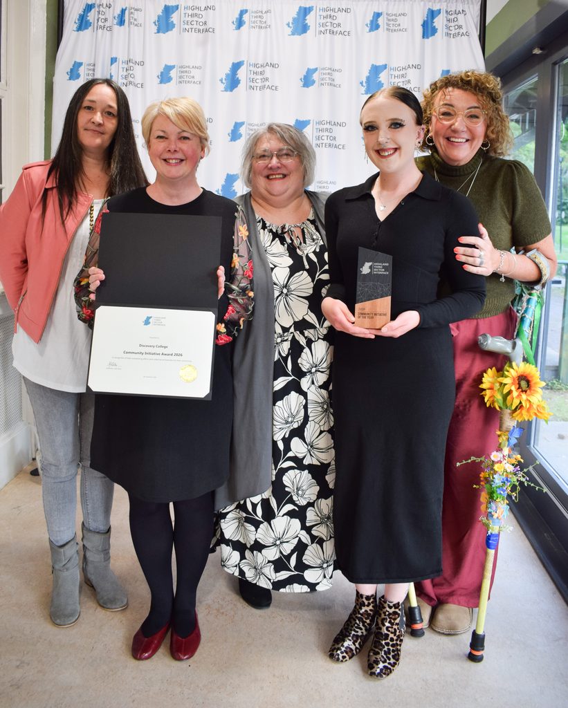 Group of women smiling while collecting an award.