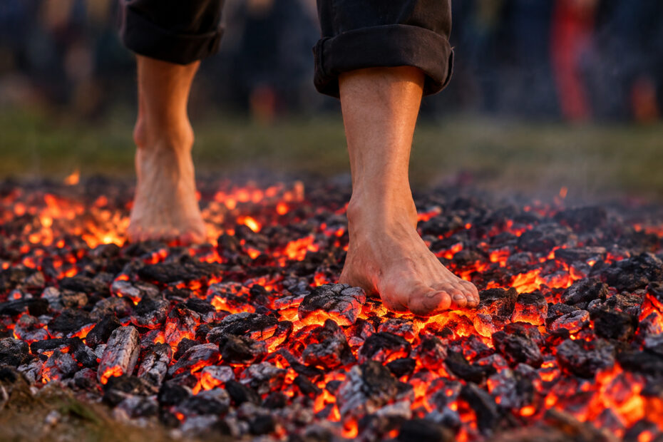 Bottom of someone's bare legs and feet walking over hot coals
